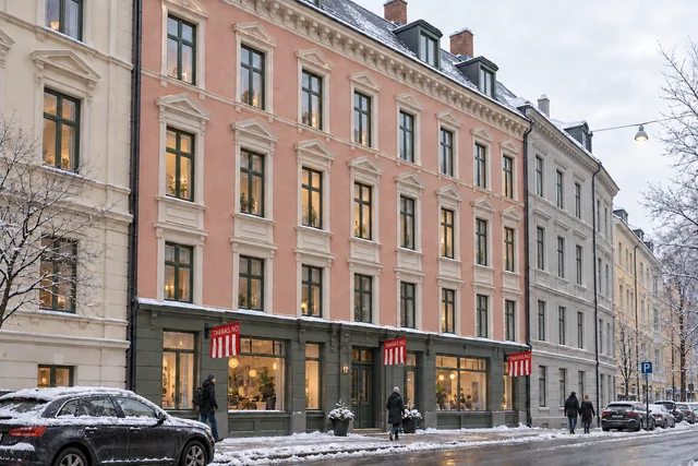 3D-illustrasjon av en snødekt bygård med røde TAKRAS.NO-varselflagg på fasadene over fortauet.